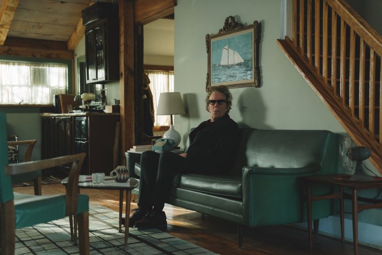 Elokuvan hahmo istumassa sohvalla.