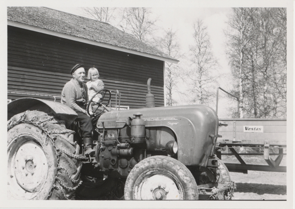Väinö ja tyttö traktorissa