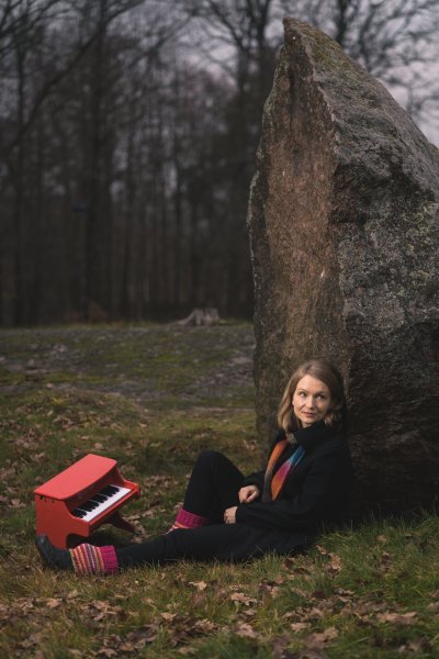 Kuva Paula Präktigistä istumassa suureen kiveen nojaten